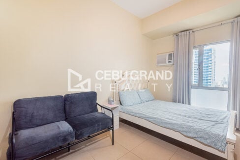 Navy velvet loveseat and bed by a window overlooking Cebu IT Park
