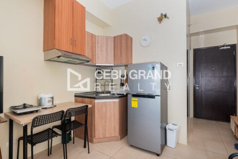 Kitchen corner with timber cabinets, refrigerator and desk with two chairs