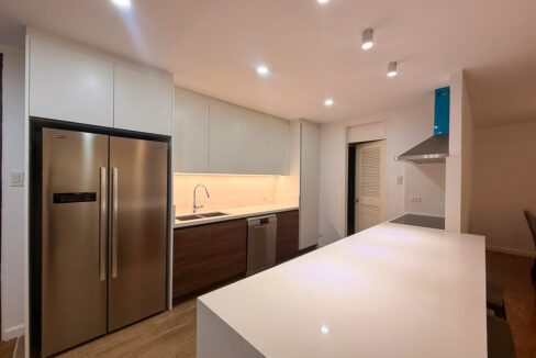 Kitchen with a side-by-side refrigerator and a long white island