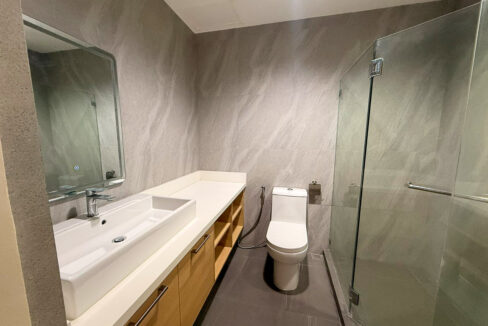 Bathroom with a glass-enclosed shower, stone-look tiles and a vessel basin