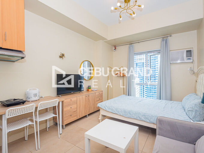Furnished 31st floor studio at Avida Riala Tower 3 with bed, sofa and kitchen corner