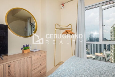 Gold garment rack and round mirror by a window overlooking Cebu IT Park