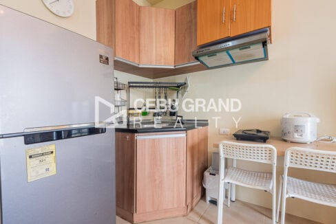 Kitchen corner with timber cabinets, range hood, sink and dining desk