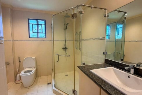 Master bathroom at North Town Residences with a frameless glass shower and granite vanity