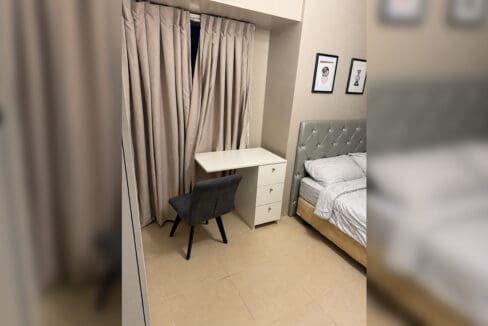 Study desk under the bedroom window beside the bed