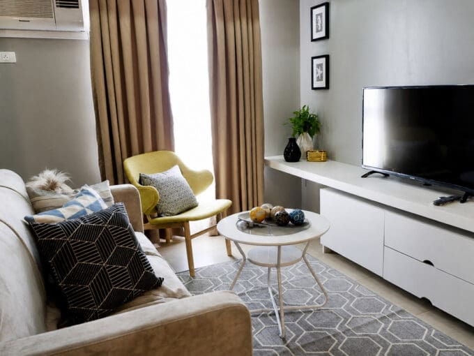 Living area with sofa, accent chair and wall-mounted flatscreen TV
