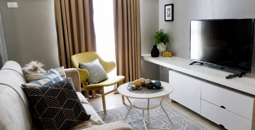 Living area with sofa, accent chair and wall-mounted flatscreen TV
