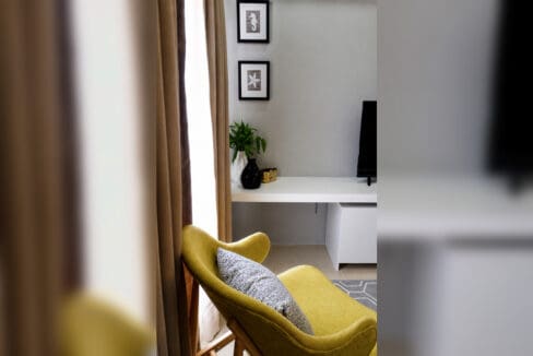 Accent chair beside the built-in media console and window