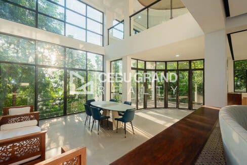 Double-height living and dining with full-height glazing in the newly renovated 10-bedroom house for sale at Maria Luisa Estate Park