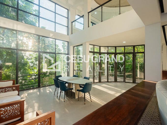 Double-height living and dining with full-height glazing in the newly renovated 10-bedroom house for sale at Maria Luisa Estate Park