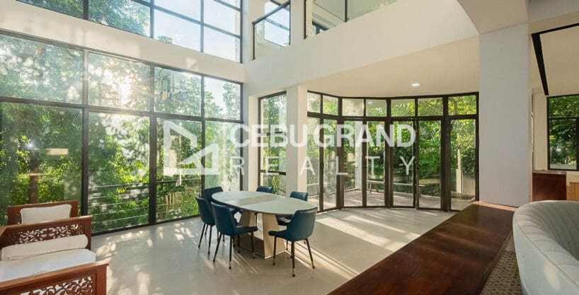 Double-height living and dining with full-height glazing in the newly renovated 10-bedroom house for sale at Maria Luisa Estate Park