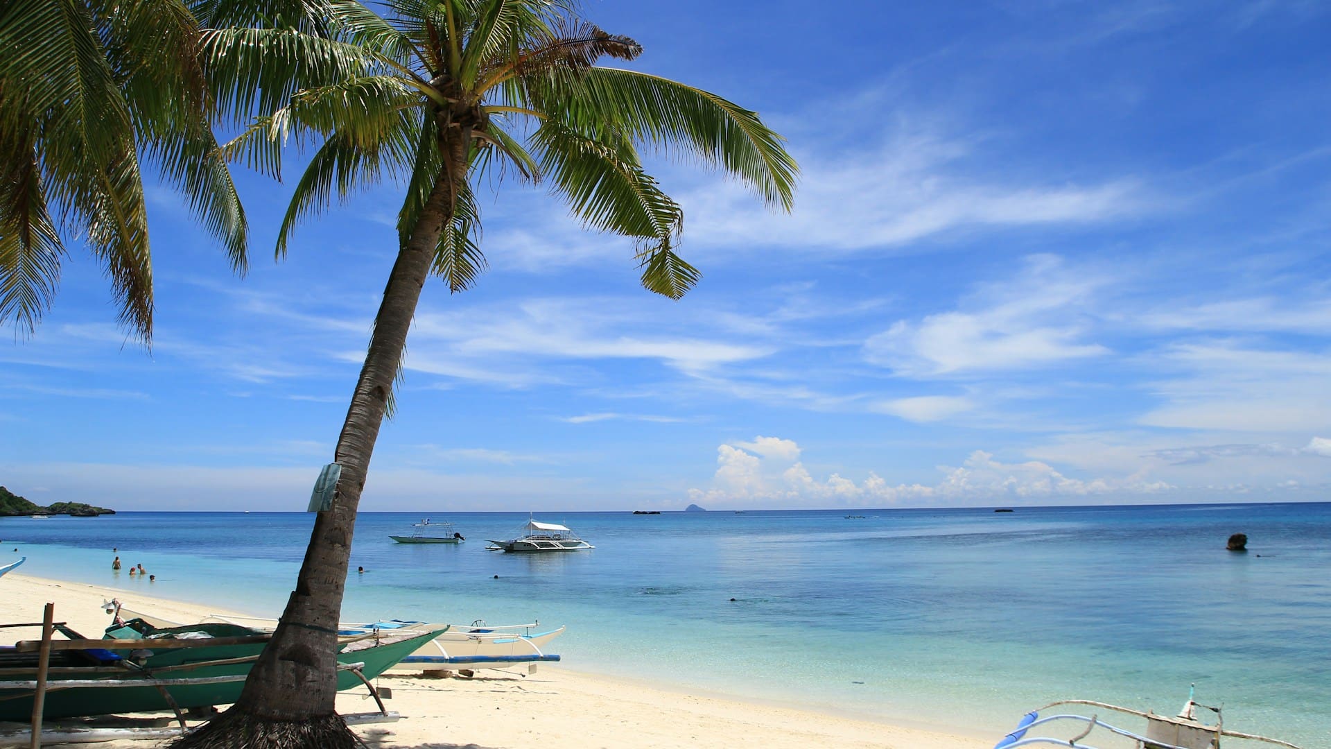 Mactan Cebu beach with palm trees and boats Philippines