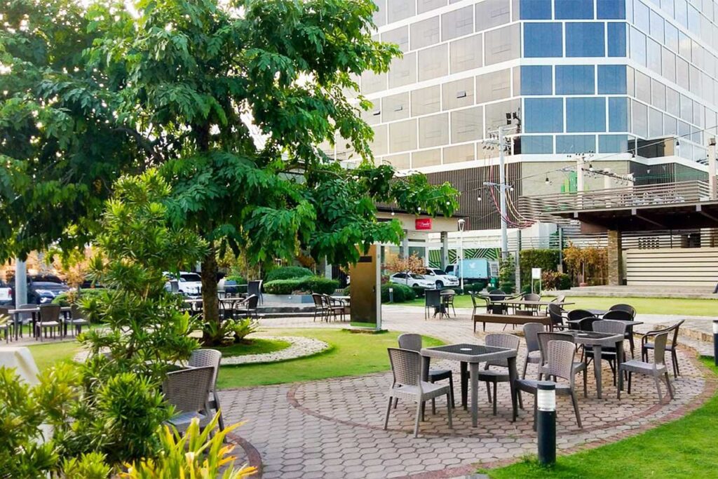 Outdoor park seating area with greenery and office buildings at Oakridge Business Park
