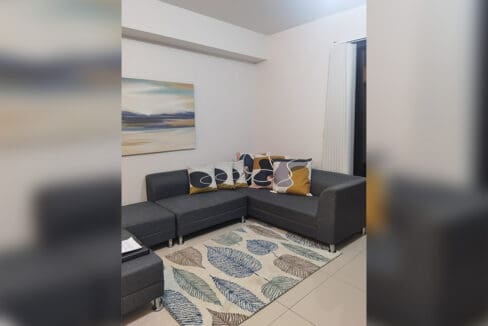 Furnished Alcoves condo for rent — second lounge with area rug
