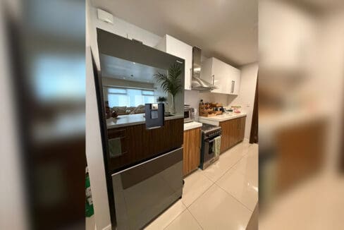 Bathroom with glass-enclosed shower and dark wood door at The Alcoves 1BR