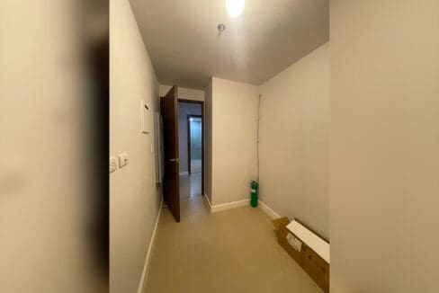 Second bedroom with two twin beds and cushioned headboards at Alcoves 2BR