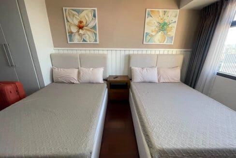 Master bedroom sitting area with accent chair and ottoman at Alcoves 2BR