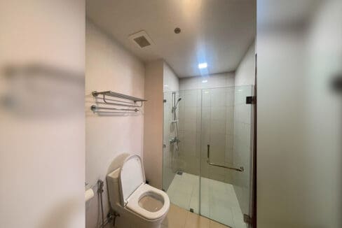 Second bathroom with black marble vanity and glass-enclosed shower at Alcoves 2BR