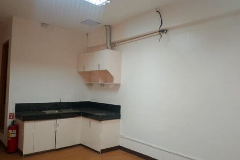 Fitted pantry with stainless sink, counter and overhead cabinets in the Cebu Yacht Club office space