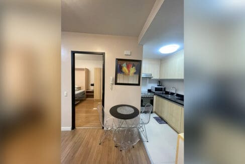 Kitchen with electric range, black granite counter, and wood cabinetry at Solinea Tower 1