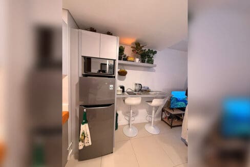 Kitchen counter with induction cooktop, sink, and white cabinets at 38 Park Avenue studio