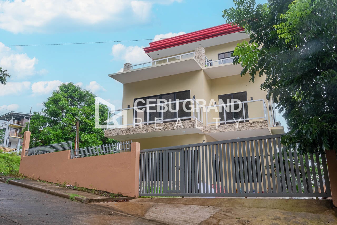 Front of the three-level house in San Lorenzo Woodlands, Binaliw, with glass-railed balconies