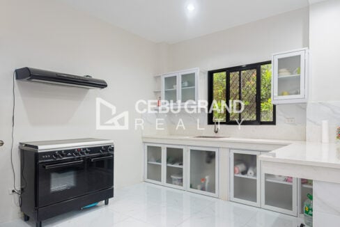 Kitchen of the San Lorenzo Woodlands house with a black double-oven gas range and range hood