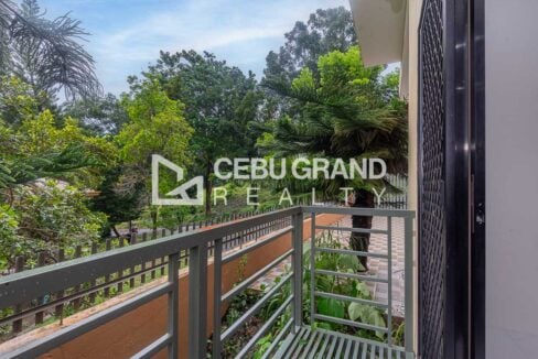 Ground-floor balcony with a metal railing above the garden