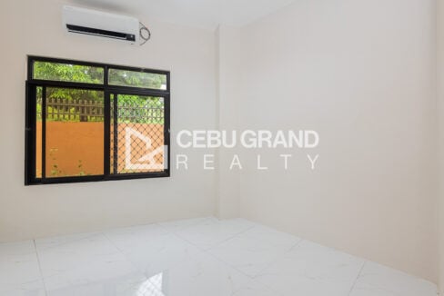 Ground-floor bedroom with split-type aircon and a screened window