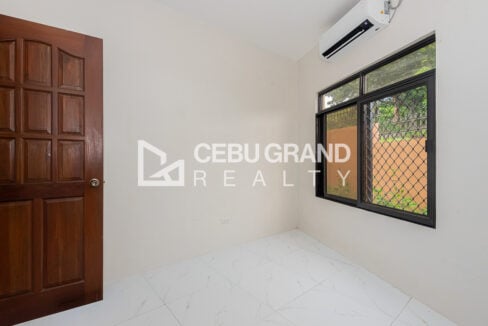 Bedroom with a wood panel door and split-type aircon
