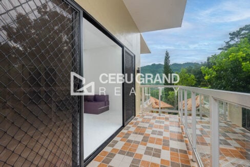Balcony with checkered tiles and glass railings looking out to the mountains