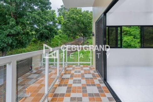Wide tiled balcony with glass railings beside the second-floor rooms