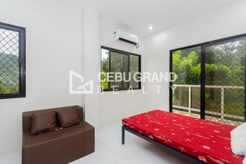 Bedroom in the Binaliw house with aircon, a bed and sliding doors to the balcony