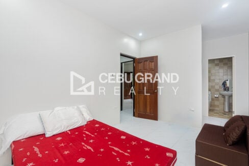 Bedroom with a wood panel door and an ensuite toilet and bath