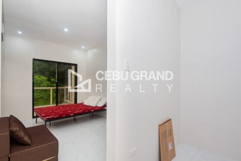 Bedroom seen through the doorway, with sliding doors to the balcony