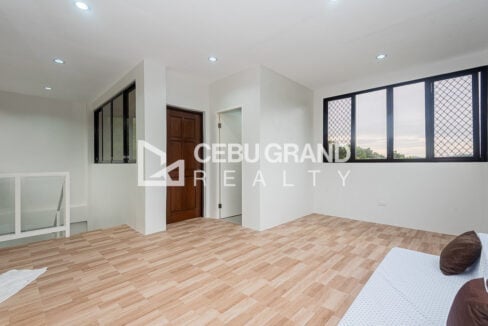 Top-floor room with wood-look tiles and wide windows