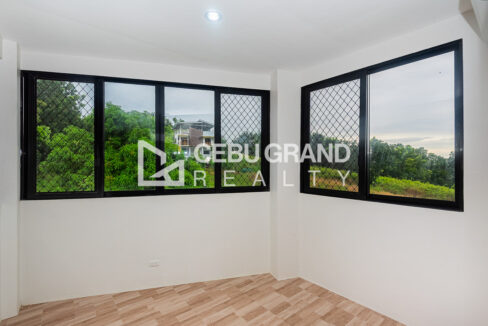 Bedroom with corner windows and wood-look tile flooring