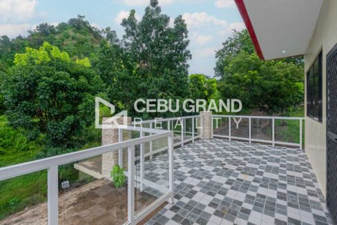 Roof terrace of the Binaliw house with stone-clad pillars, glass railings and checkered tiles