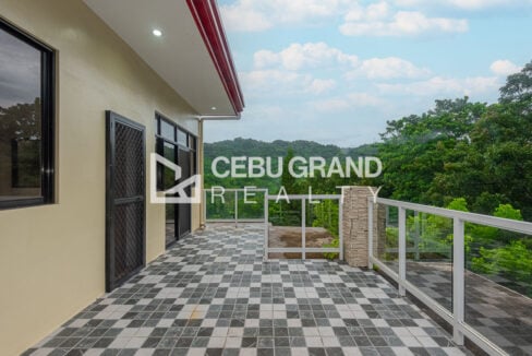 Wide checkered-tile roof terrace with glass railings beside the top floor