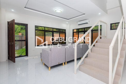 Living area with a crystal ceiling light, front door and staircase