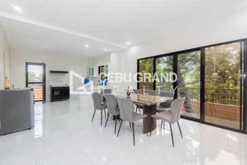 Dining table for eight beside the kitchen, with sliding glass doors to a balcony