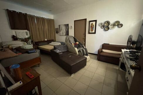 Second living room with wall-mounted TV and console at Andres Abellana compound