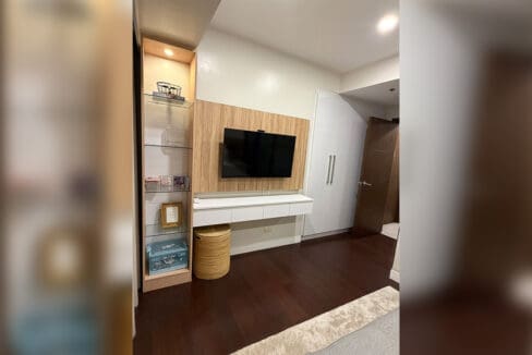 Alcoves condo for sale — guest bath with round mirror and wood-slat wall