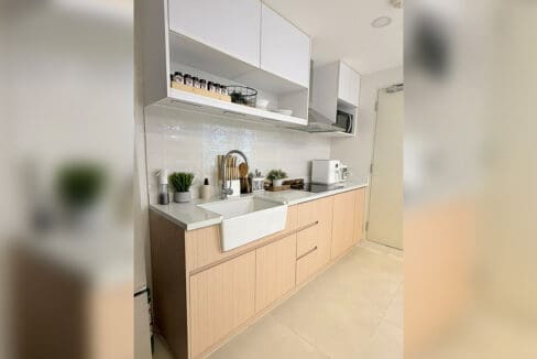 Alcoves condo for sale — kitchen with farmhouse sink and induction cooktop