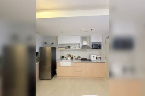 Alcoves condo for sale — chef kitchen with wood-and-white cabinets