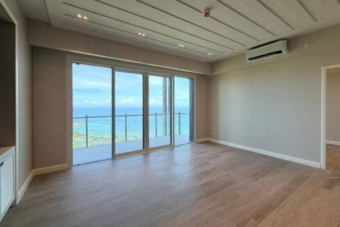 Second bedroom with wooden slat feature wall and sea view at Aruga Resort