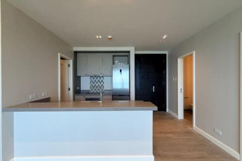 Modern kitchen with induction cooktop, oven, and stainless refrigerator at Aruga
