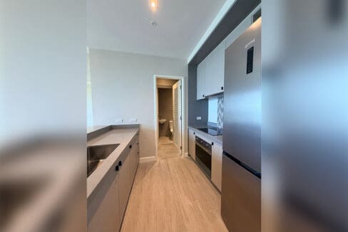 Kitchen counter with sink and cabinets at Aruga Resort 2BR condo