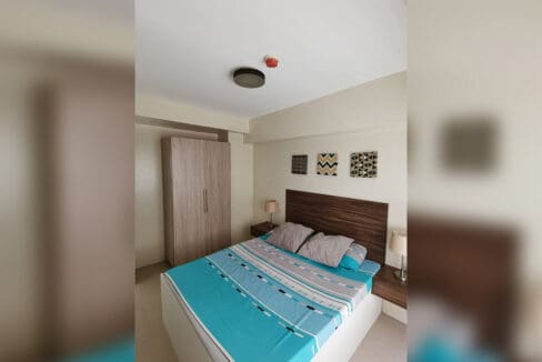Bedroom with full-size king bed, timber headboard and mirrored wardrobe