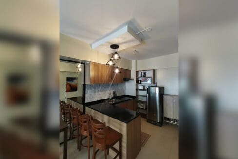 Kitchen with black granite counter, induction cooktop, rangehood and two-door refrigerator